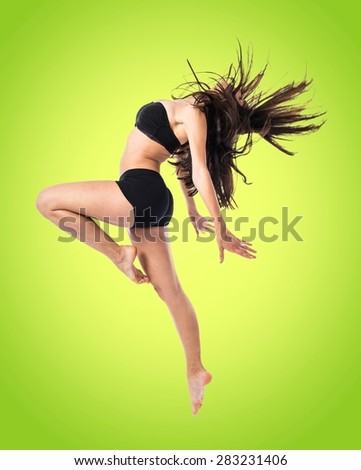 Young fitness female jumping over colorful background