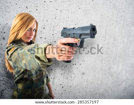 military woman shooting a gun over textured background