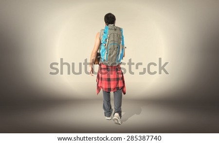 Young backpacker walking over textured background
