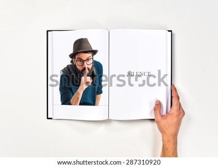 Artist making silence gesture printed on book