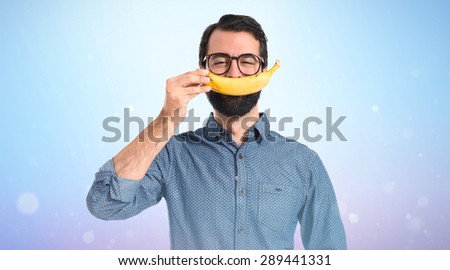 Happy young hipster man with banana
