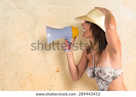 Woman in bikini shouting by megaphone