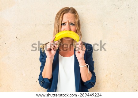 Blonde girl with banana as mouth over textured background