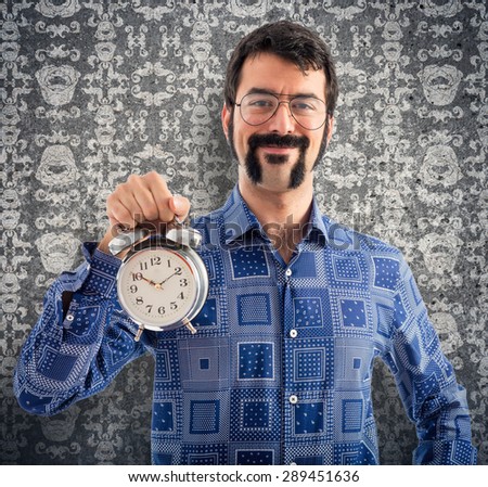 Vintage young man holding vintage clock over vintage background