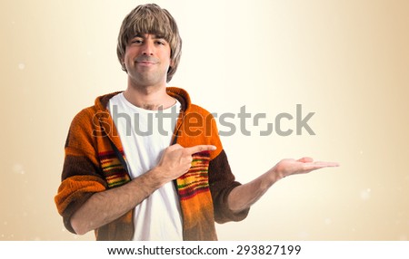Blonde man holding something over ocher background