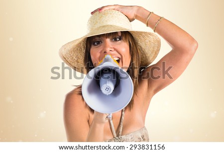 Woman in bikini shouting by megaphone over ocher background