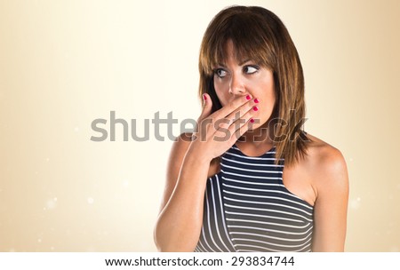 Woman doing surprise gesture over ocher background