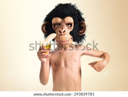 Child with monkey mask eating a banana over ocher background