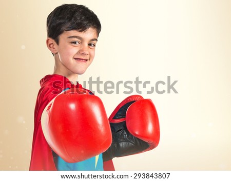 Child dressed like superhero over ocher background