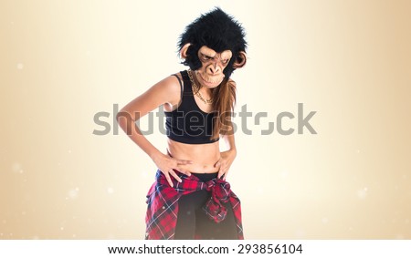 Woman with monkey mask over ocher background
