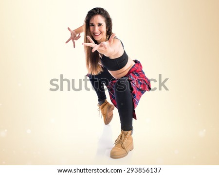 Woman with monkey mask dancing over ocher background