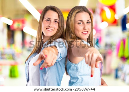 Girls pointing to the front on unfocused background