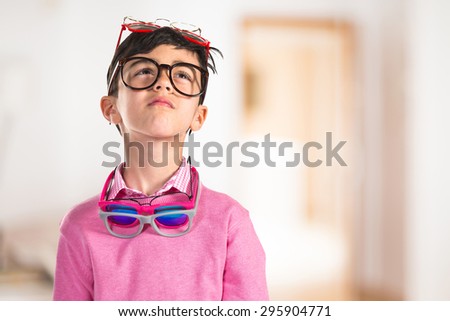 Boy thinking with many glasses inside house