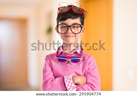 Happy boy with many glasses inside house