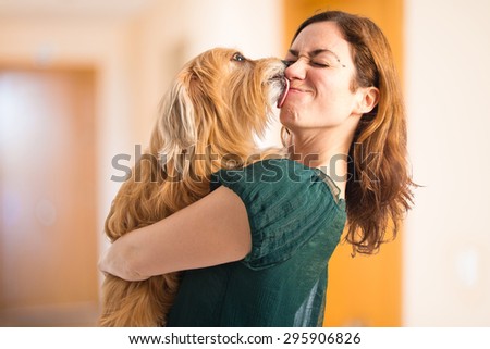 Dog kissing her owner inside house