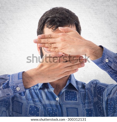 Vintage young man covering his face over grey background