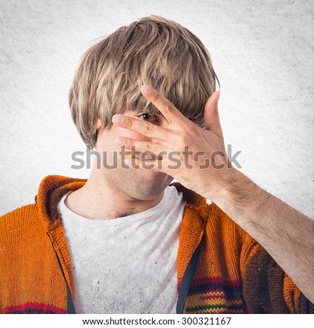 Blonde man covering his face