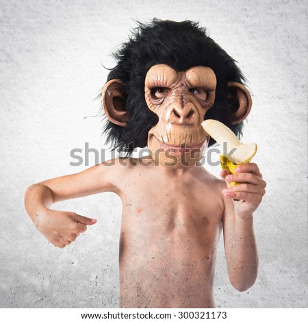 Child with monkey mask eating a banana