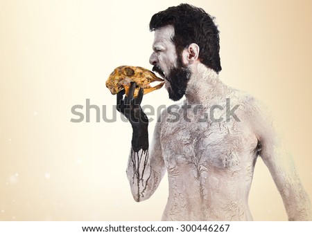 Primitive man eating a rabbit skull