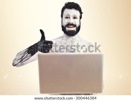 Prehistoric man with laptop over ocher background