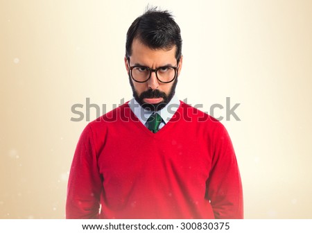 Sad hipster man over ocher background