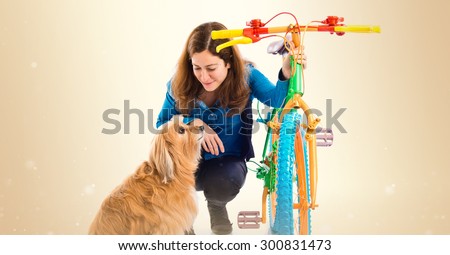 Woman and dog with colorful bike over ocher background