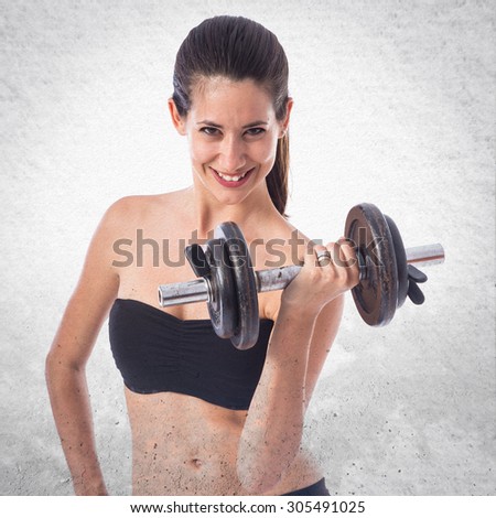 Sport woman doing weightlifting over textured background