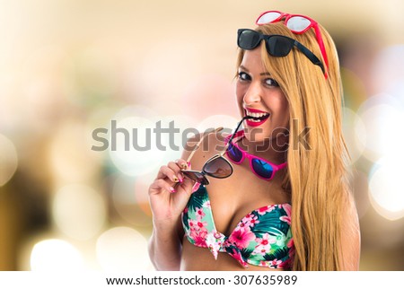 Sexy woman wearing many sunglasses on unfocused background