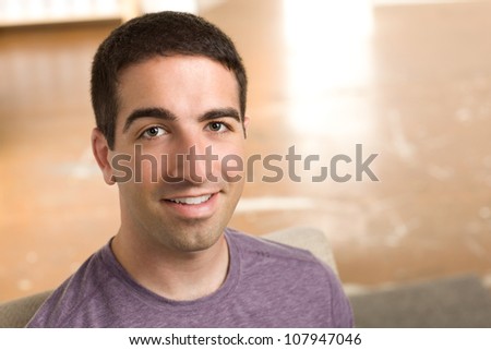 Head shot of good looking guy in purple shirt smiling at camera.