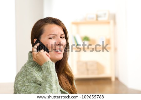 Beautiful white female at home wearing a green sweater with straight long brunette hair.