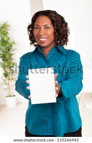 Cute African American woman with dark brown hair wearing a blue shirt.