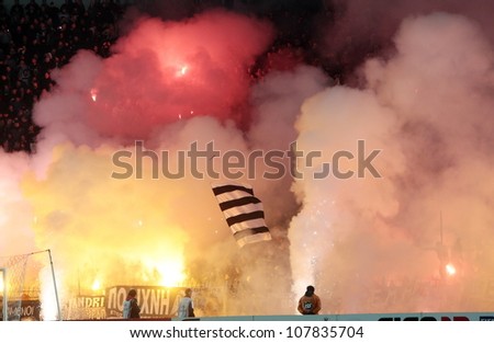 THESSALONIKI, GREECE - FEB 5: Fans and supporters of PAOK team light flares in football match between Paok and Olympiacos cheering for their team goals on February 5, 2012 in Thessaloniki, Greece.