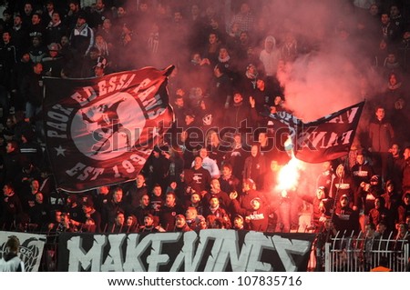 THESSALONIKI, GREECE - NOV 20: Fans and supporters of PAOK team light flares in football match between Paok and Panetolikos cheering for their team goals on November 20, 2011 in Thessaloniki, Greece.