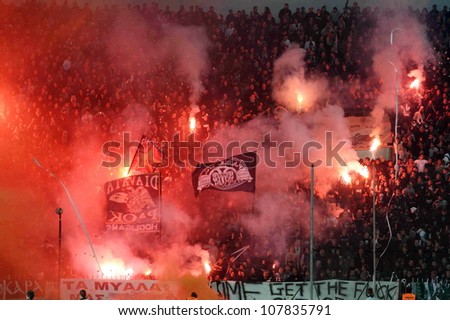 THESSALONIKI, GREECE - OCT 30: Fans and supporters of PAOK team light flares in football match between Paok and Panathinaikos cheering for their team on October 30, 2011 in Thessaloniki, Greece.