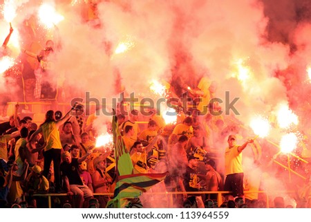 THESSALONIKI, GREECE - AUGUST 5: Fans and supporters of ARIS team light flares in football match between Aris and Boca Juniors cheering for their team goals on August 5, 2009 in Thessaloniki, Greece.