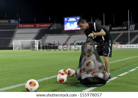 THESSALONIKI, GREECE -SEPT 19: Paok\'s trainer emptying a sack of Europa League football balls in the field before the match Paok vs Shakhter Karagandy on September 19, 2013 in Thessaloniki, Greece.