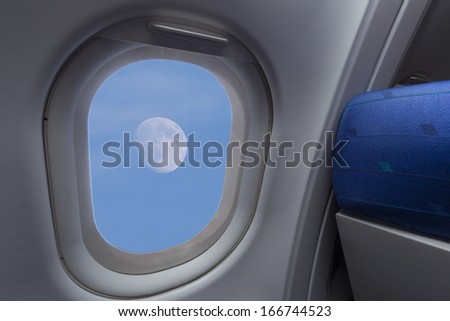 Moon in the sky as seen through an airplane window