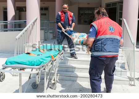 THESSALONIKI, GREECE- APRIL 24, 2013: Emergency team assisting injured teacher during during an earthquake exercise at 6th primary school in Thessaloniki, Greece.