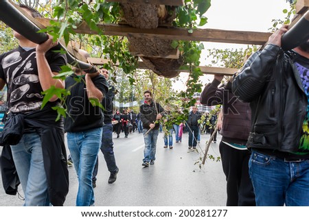 THESSALONIKI, GREECE- NOVEMBER 24, 2012: Men carrying trees. Protest against gold mining for the mine in Stratoni, Halkidiki. The protest took place in Thessaloniki, Greece.