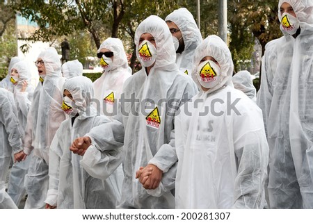 THESSALONIKI, GREECE- NOVEMBER 24, 2012: Protesters wearing chemical protective suits hold hands. Protest against gold mining in Stratoni, Halkidiki. The protest took place in Thessaloniki, Greece.