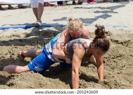 KATERINI, GREECE- JULY 6, 2014: Two female athletes wrestle on sand during the First World Championship Beach Wrestling in 2014 in Katerini, Greece.