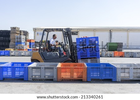 NAOUSSA GREECE- AUGUST 20 2014: A worker transporting boxes with fruits of Agricultural Cooperative of Naoussa Greece. The famous \