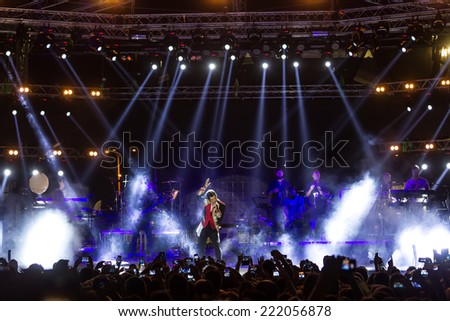 THESSALONIKI, GREECE, SEPTEMBER 11, 2014: Singer Sakis Rouvas performing at MAD North Stage festival by Thessaloniki International Fair. Blur stage spotlights with laser rays in the background.