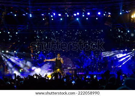 THESSALONIKI, GREECE, SEPTEMBER 11, 2014: Singer Sakis Rouvas performing at MAD North Stage festival by Thessaloniki International Fair. Blur stage spotlights with laser rays in the background.