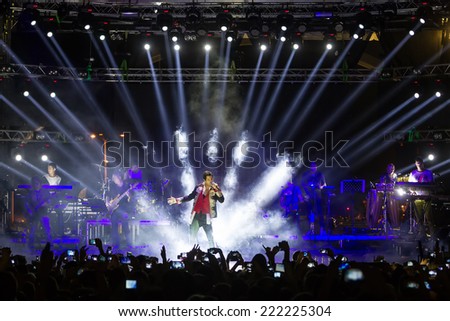 THESSALONIKI, GREECE, SEPTEMBER 11, 2014: Singer Sakis Rouvas performing at MAD North Stage festival by Thessaloniki International Fair. Blur stage spotlights with laser rays in the background.