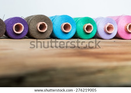 Spools of thread on wooden  background. Old sewing accessories. colored threads