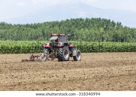 Thessaloniki, Greece - June 21, 2015: A tractor planting wheat in the fertile farm fields of Greece