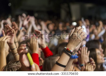 THESSALONIKI, GREECE, SEPTEMBER 13, 2013: Cheering crowd standing with raised hands up and clapping at music concert.