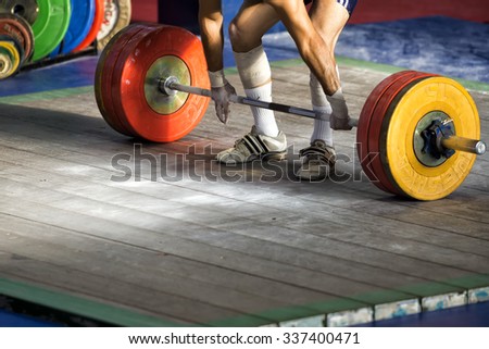 Thessaloniki, Greece, October 3, 2015: Hands and feet athlete on the barbell. Young athlete preparing to lift weights during the Greek Weightlifting Championship