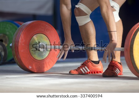 Thessaloniki, Greece, October 3, 2015: Hands and feet athlete on the barbell. Young athlete preparing to lift weights during the Greek Weightlifting Championship